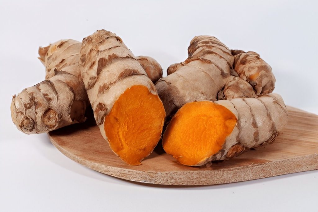 Akar kunyit dengan irisan dai talenan dan latar belakang putih (Tangkapan Layar)