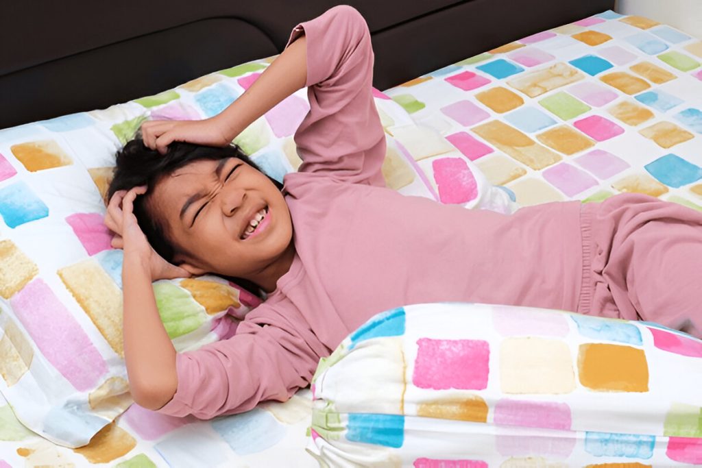 Gadis kecil menunjukkan gerakan kesal saat tidur di tempat tidurnya (shutterstock.com)