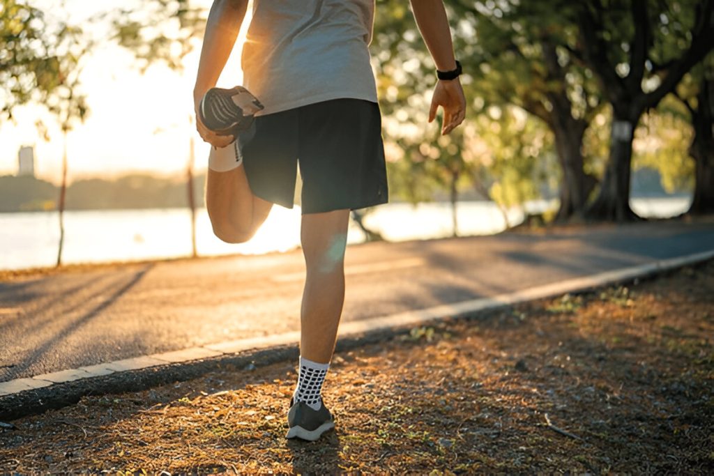 Pelari pria meregangkan kaki dan telapak kaki dan bersiap untuk jogging dan berlari di taman umum di luar ruangan saat matahari terbenam, (shutterstock.com)