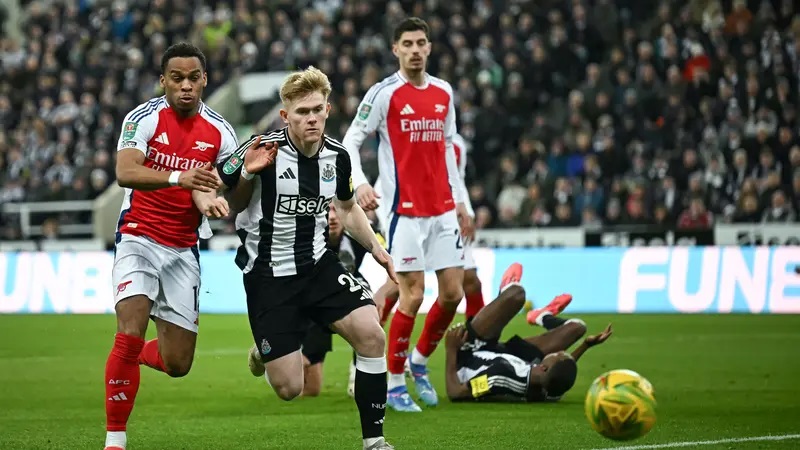 Bek Arsenal asal Belanda, Jurrien Timber (kiri) berebut bola dengan gelandang Newcastle United asal Inggris, Lewis Hall selama pertandingan sepak bola leg kedua semifinal Piala Liga Inggris antara Newcastle United dan Chelsea di St James' Park, di Newcastle-upon-Tyne, Inggris timur laut, pada tanggal 5 Februari 2025.(Paul ELLIS / AFP)