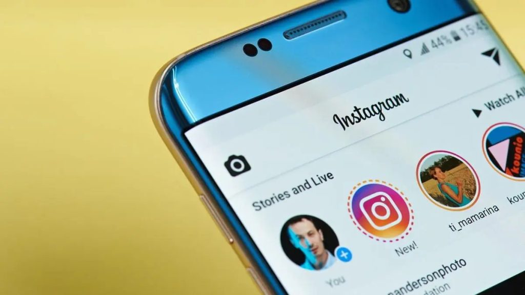 Tangan memegang smartphone menampilkan antarmuka aplikasi instagram story