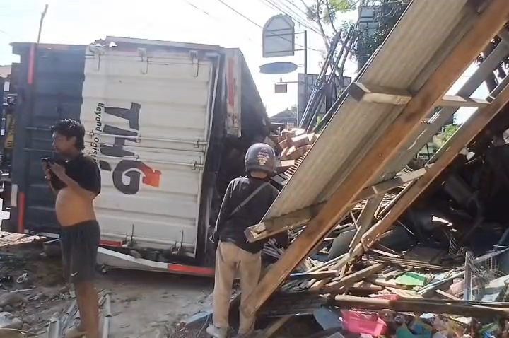 Diduga mengalami rem blong, truk kontainer bermuatan air mineral kemasan hilang kendali dan menabrak sebuah sepeda motor serta warung di tikungan menurun Jalan Raya Cirebon–Kuningan (Foto : Darfan)