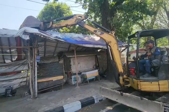 Petugas gabungan menertibkan bangunan liar dan reklame di Jalan Kesambi, Kota Cirebon. (Foto : Darfan)